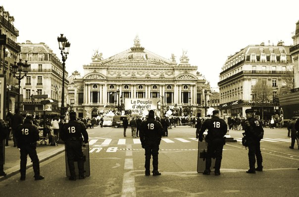 پیرس میں مظاہرے کے دوران پولیس — france curfew paris کے نفاذ کے بعد کی صورتحال