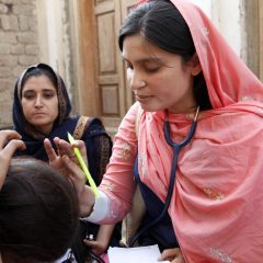 پاکستان میں موبائل ہیلتھ کلینک پر مریض کا معائنہ کرتی خاتون ڈاکٹر — clinic on wheels ajk صحت سہولت