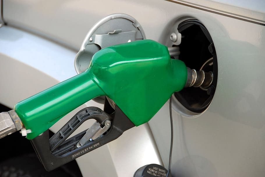 گاڑی میں فیول نوزل لگا کر پیٹرول بھرواتا شہری — ڈیلی فیول پرائسنگ (daily fuel pricing) پر کالم