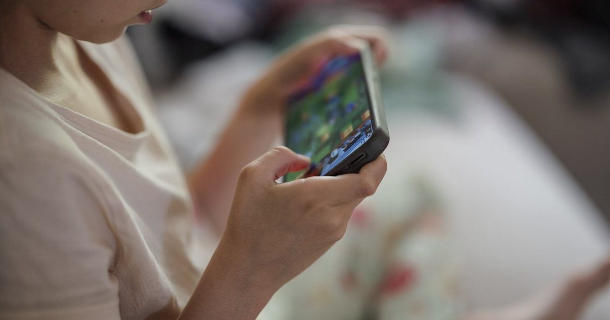 اسمارٹ فون میں مگن بچہ — online child safety کے لیے والدین کی ڈیجیٹل نگرانی ناگزیر