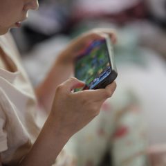 اسمارٹ فون میں مگن بچہ — online child safety کے لیے والدین کی ڈیجیٹل نگرانی ناگزیر