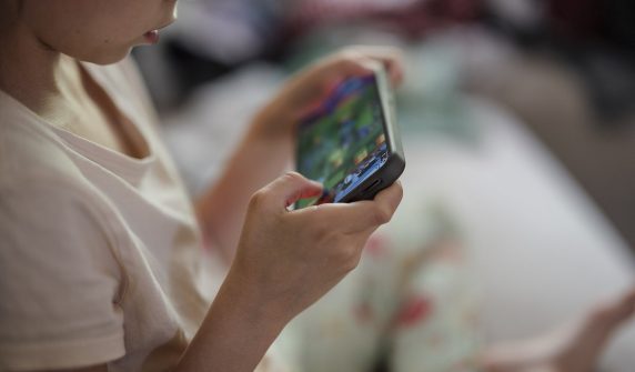 اسمارٹ فون میں مگن بچہ — online child safety کے لیے والدین کی ڈیجیٹل نگرانی ناگزیر